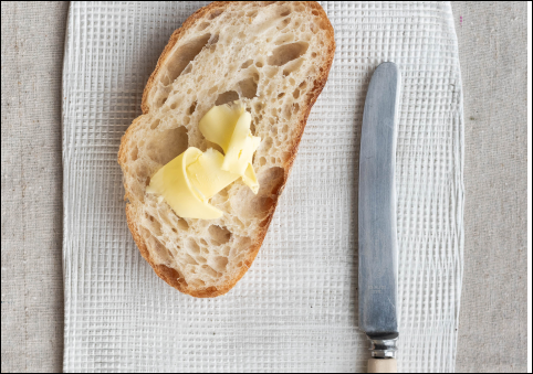 bread on butter next to butter knife